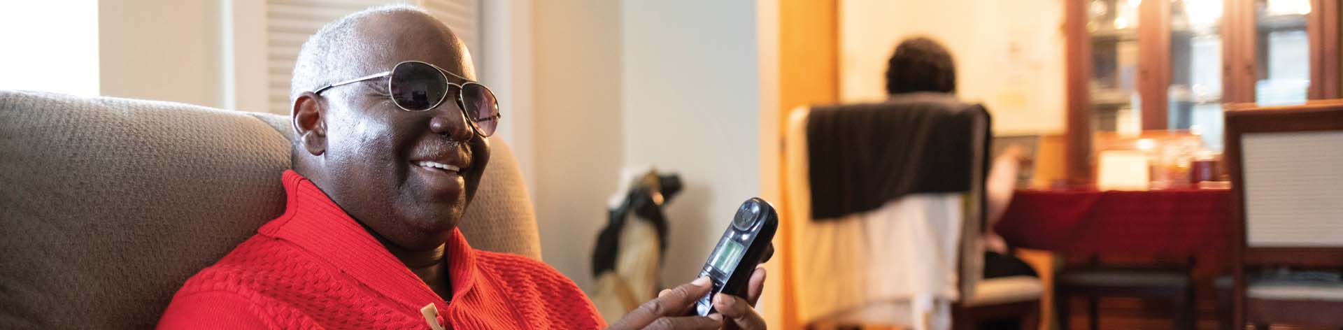 Blind man using a phone to access NFB Newsline®.