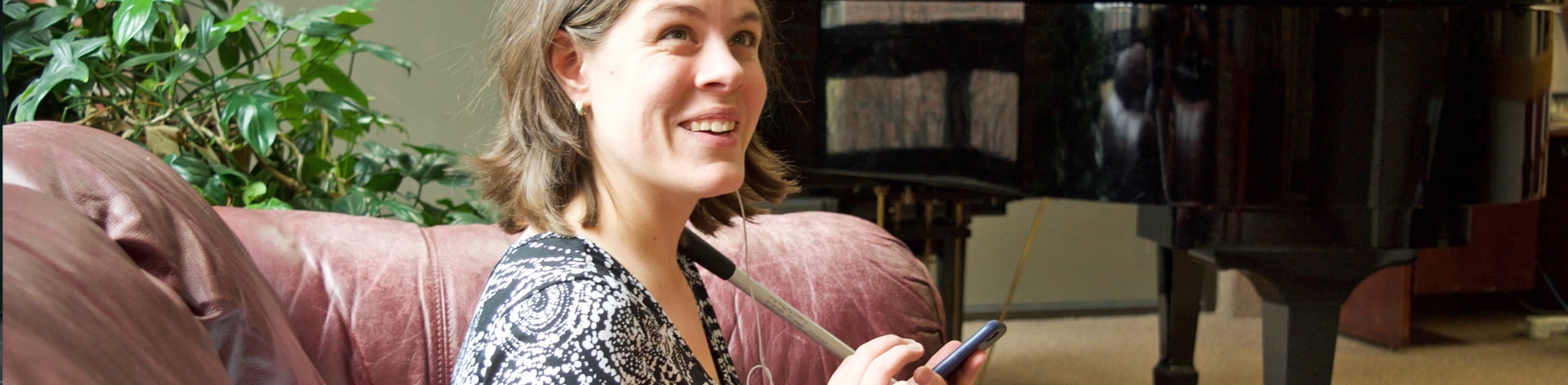 blind woman listens to NFB newsline on her phone.