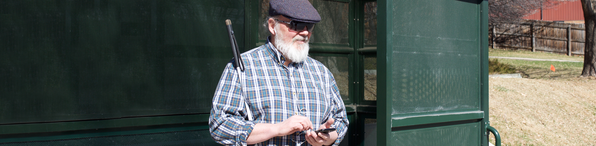 Blind man listening to NFB Newsline® while waiting for a bus.